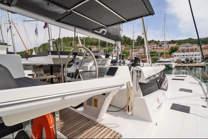 First Life Yacht Photos Pics 2025 Fountaine Pajot Tanna 47 catamaran docked, featuring sleek design and modern helm station.