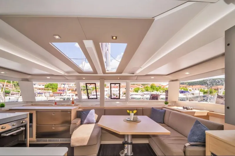 First Life Yacht Photos Pics Luxurious interior of 2025 Fountaine Pajot Tanna 47 catamaran with modern design and spacious seating.