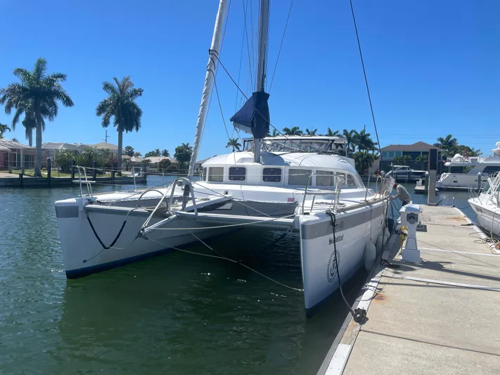 Seabatical Yacht Photos Pics 2016 Lagoon 380 catamaran docked in a sunny marina with palm trees.