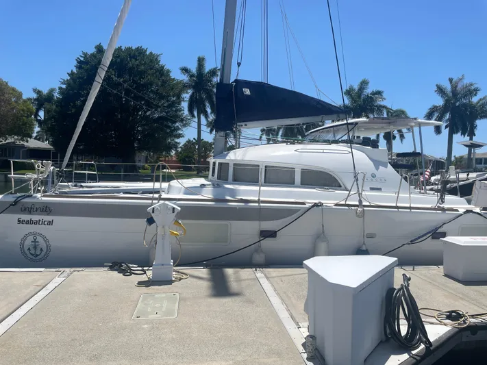 Seabatical Yacht Photos Pics 2016 Lagoon 380 catamaran docked under clear blue sky with palm trees.