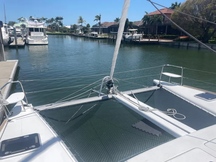 Seabatical Yacht Photos Pics 2016 Lagoon 380 catamaran docked in a serene marina with palm trees.
