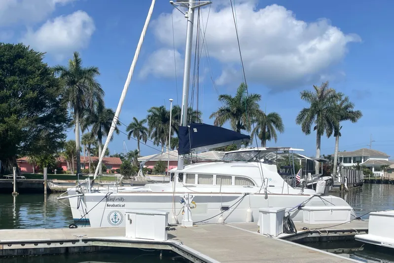 Seabatical Yacht Photos Pics 2016 Lagoon 380 catamaran docked in a sunny marina with palm trees.