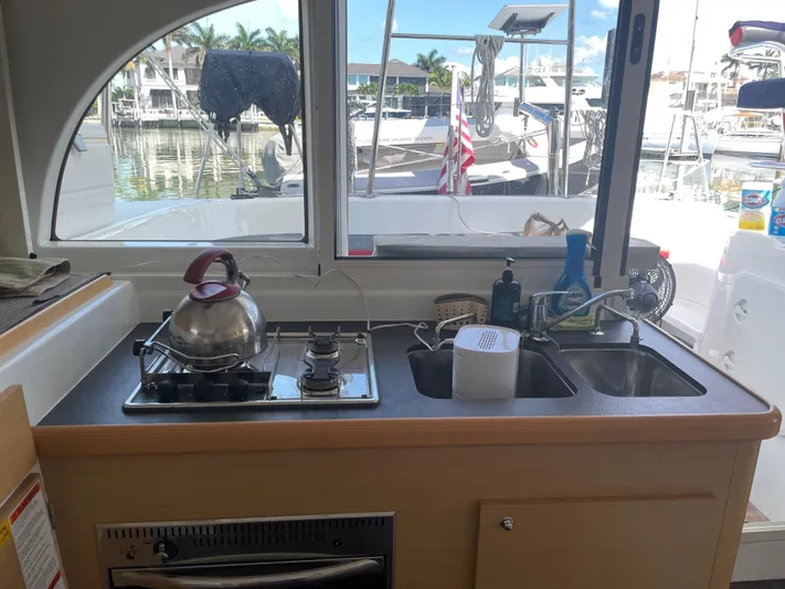 Seabatical Yacht Photos Pics Interior view of a 2016 Lagoon 380 catamaran kitchen with stove and sink.