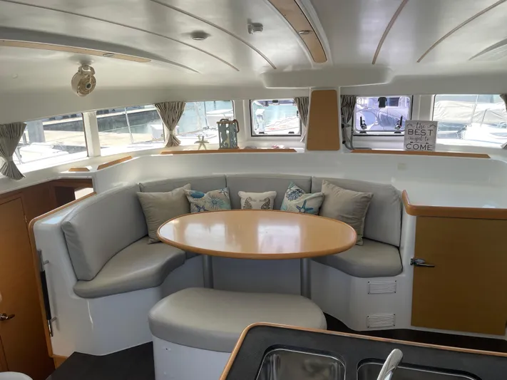 Seabatical Yacht Photos Pics Interior of 2016 Lagoon 380 catamaran with cozy seating and round table.