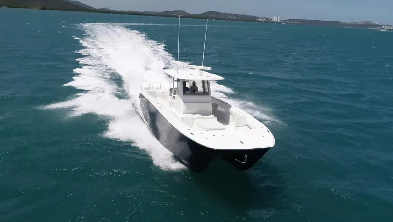 Warevel Yacht Photos Pics 2019 Invincible 40 Catamaran cruising on open water, creating a wake behind.
