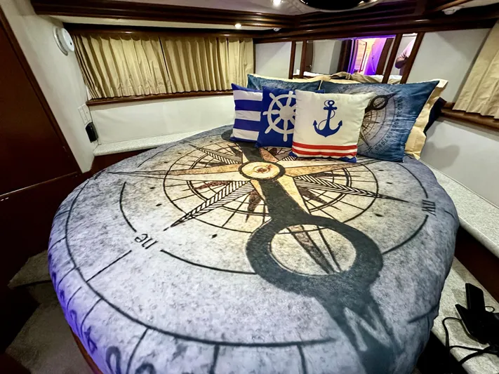 Journey Yacht Photos Pics Nautical-themed bedroom in a 1999 Carver 450 Pilothouse yacht with compass bedding and decorative pillows.