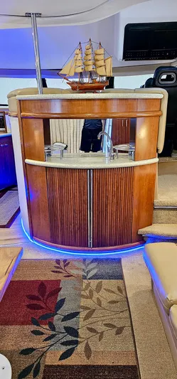 Journey Yacht Photos Pics Interior of 1999 Carver 450 Pilothouse with wooden cabinetry and decorative ship model.