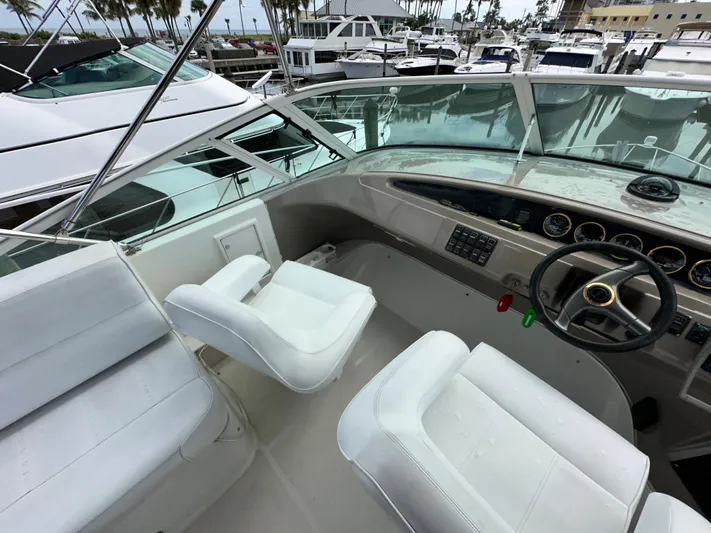 Journey Yacht Photos Pics 1999 Carver 450 Pilothouse yacht helm with white seats and marina view.