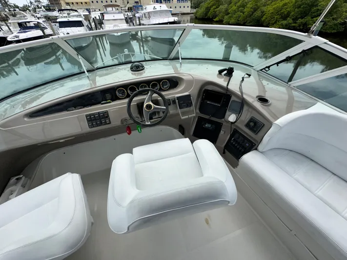 Journey Yacht Photos Pics 1999 Carver 450 Pilothouse yacht helm with white seating and control panel.