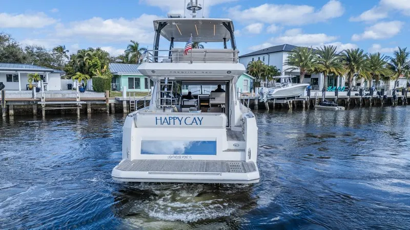 Happy Cay Yacht Photos Pics Prestige 520 Flybridge yacht, 2021 model, cruising in a scenic waterfront area.