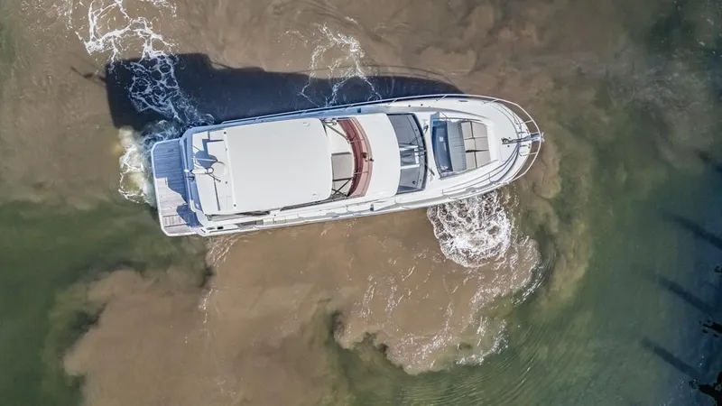 Happy Cay Yacht Photos Pics Aerial view of 2021 Prestige 520 Flybridge yacht navigating through water.