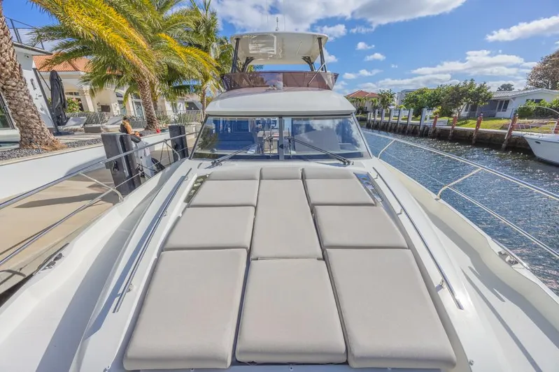 Happy Cay Yacht Photos Pics Prestige 520 Flybridge 2021 yacht docked by palm trees and waterfront homes.