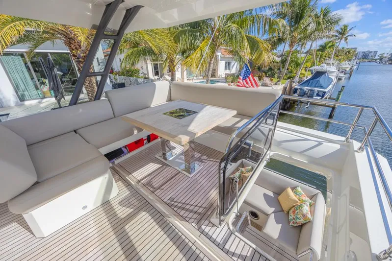 Happy Cay Yacht Photos Pics Luxurious 2021 Prestige 520 Flybridge yacht with elegant seating and scenic waterfront view.