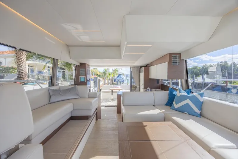 Happy Cay Yacht Photos Pics Luxurious interior of 2021 Prestige 520 Flybridge yacht with modern seating and large windows.