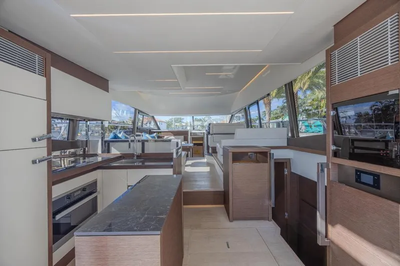 Happy Cay Yacht Photos Pics Luxurious interior of 2021 Prestige 520 Flybridge yacht with modern kitchen and seating area.