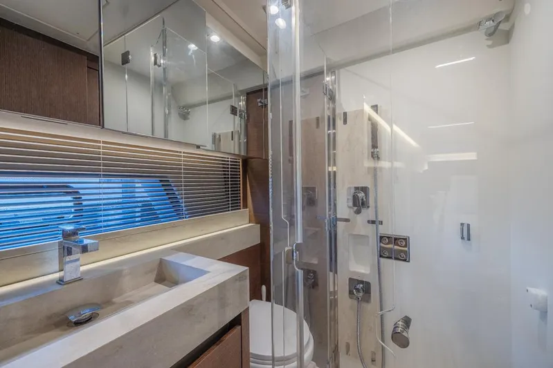 Happy Cay Yacht Photos Pics Luxurious bathroom in 2021 Prestige 520 Flybridge yacht with modern fixtures and glass shower.