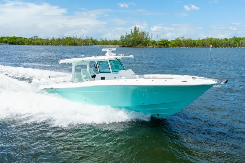  Yacht Photos Pics 2026 HCB 42 Lujo boat cruising on a sunny day, turquoise hull, white deck.