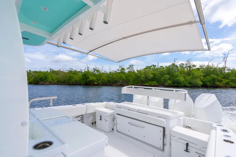  Yacht Photos Pics Luxurious 2026 HCB 42 Lujo boat interior with white seating and canopy on a scenic waterway.