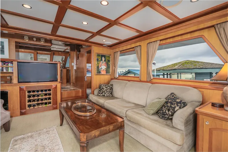 Folie Deux Yacht Photos Pics Luxurious 2005 President 680 Skylounge interior with elegant wood paneling and comfortable seating.