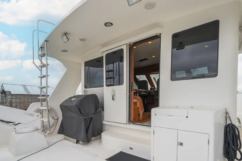 Folie Deux Yacht Photos Pics 2005 President 680 Skylounge yacht deck with outdoor seating and access to interior cabin.