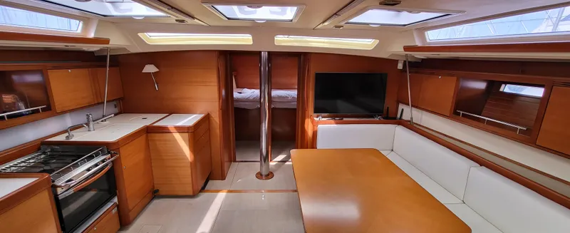 Refit Totale Anno 2023/2024 Yacht Photos Pics Luxurious interior of 2007 Dufour 525 Grand Large yacht with modern kitchen and seating area.