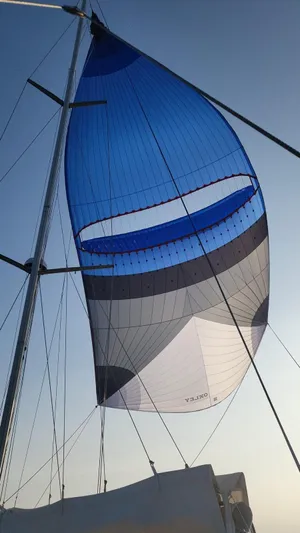 Refit Totale Anno 2023/2024 Yacht Photos Pics Sail of a 2007 Dufour 525 Grand Large yacht against a clear sky.