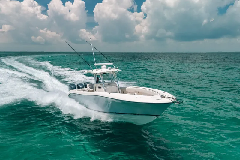  Yacht Photos Pics 2008 Hydra-Sports Vector 3300 CC cruising on turquoise ocean under cloudy sky.