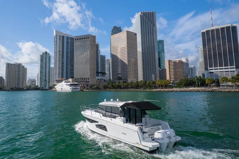  Yacht Photos Pics Jeanneau NC 1095 boat cruising near city skyline, 2019 model.