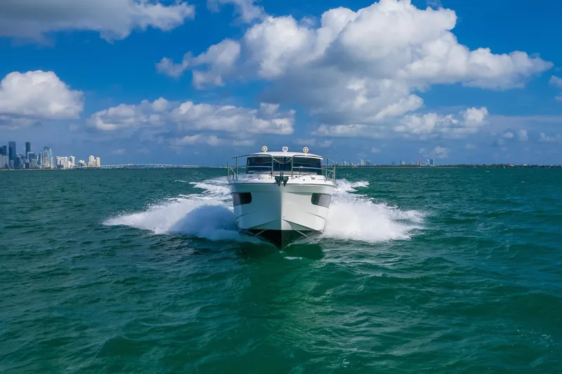  Yacht Photos Pics 2019 Jeanneau NC 1095 cruising on open water under a bright blue sky.
