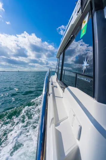  Yacht Photos Pics 2019 Jeanneau NC 1095 cruising on open water under a clear blue sky.