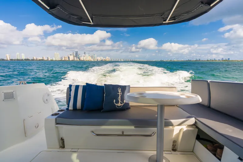  Yacht Photos Pics Jeanneau NC 1095 boat interior with ocean view, 2019 model, featuring cushions and table.