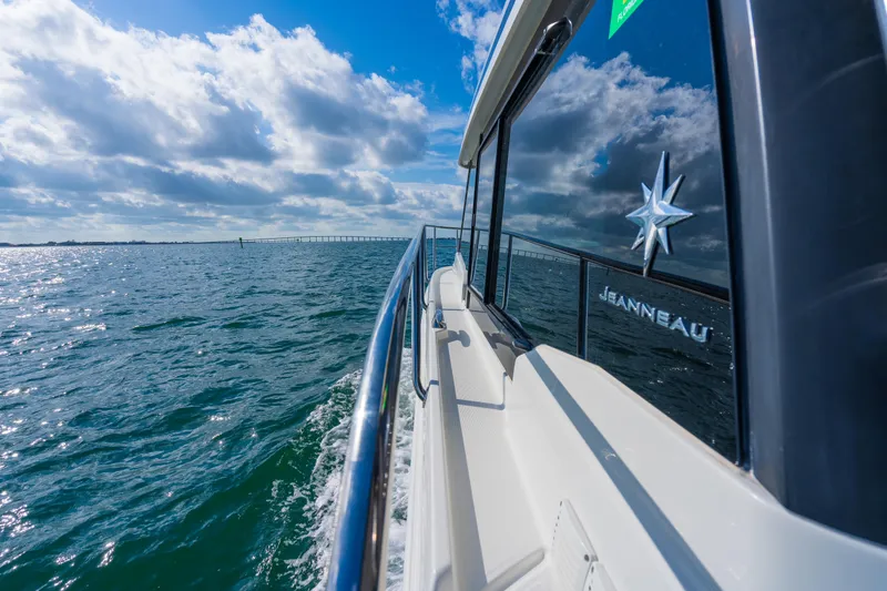  Yacht Photos Pics 2019 Jeanneau NC 1095 cruising on open water under a partly cloudy sky.