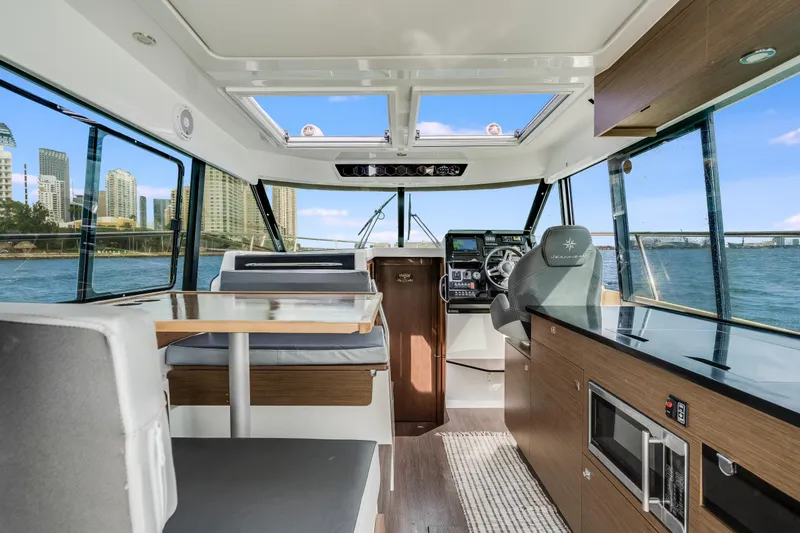  Yacht Photos Pics Interior of 2019 Jeanneau NC 1095 boat with modern seating and navigation area.