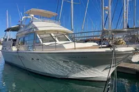 1991 Trader 47 yacht docked in marina, clear blue sky, calm water reflections.