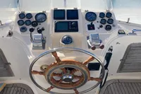 Helm of 1991 Trader 47 yacht with wooden steering wheel and navigation instruments.