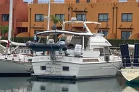 1991 Trader 47 yacht docked in marina, surrounded by colorful buildings.
