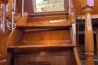 Wooden staircase inside 1991 Trader 47 yacht, showcasing polished finish and elegant design.