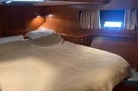 Cozy cabin interior of 1991 Trader 47 yacht with wooden finish and comfortable bedding.