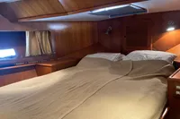 Cozy cabin interior of 1991 Trader 47 yacht with wooden paneling and double bed.