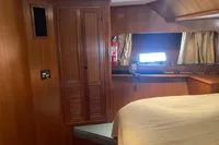 Interior cabin of 1991 Trader 47 yacht with wooden paneling and window.