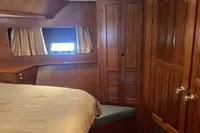 Cozy cabin interior of 1991 Trader 47 yacht with wooden furnishings and window.