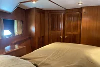 Cozy cabin interior of 1991 Trader 47 yacht with wooden paneling and bed.