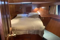 Cozy cabin interior of 1991 Trader 47 yacht with wooden finish and double bed.