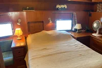Cozy cabin interior of 1991 Trader 47 yacht with wooden furnishings and ambient lighting.