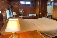 Cozy bedroom in 1991 Trader 47 yacht with wooden interior and soft lighting.