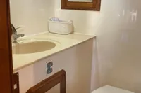 1991 Trader 47 yacht bathroom with sink, mirror, and toilet.
