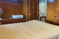 Cozy bedroom interior of 1991 Trader 47 yacht with wooden furnishings and a comfortable bed.