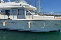 1991 Trader 47 yacht docked in marina, side view with clear blue sky.