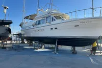 1991 Trader 47 yacht "Annila Too" on dry dock under clear blue sky.