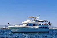 1991 Trader 47 yacht on calm water under clear blue sky.